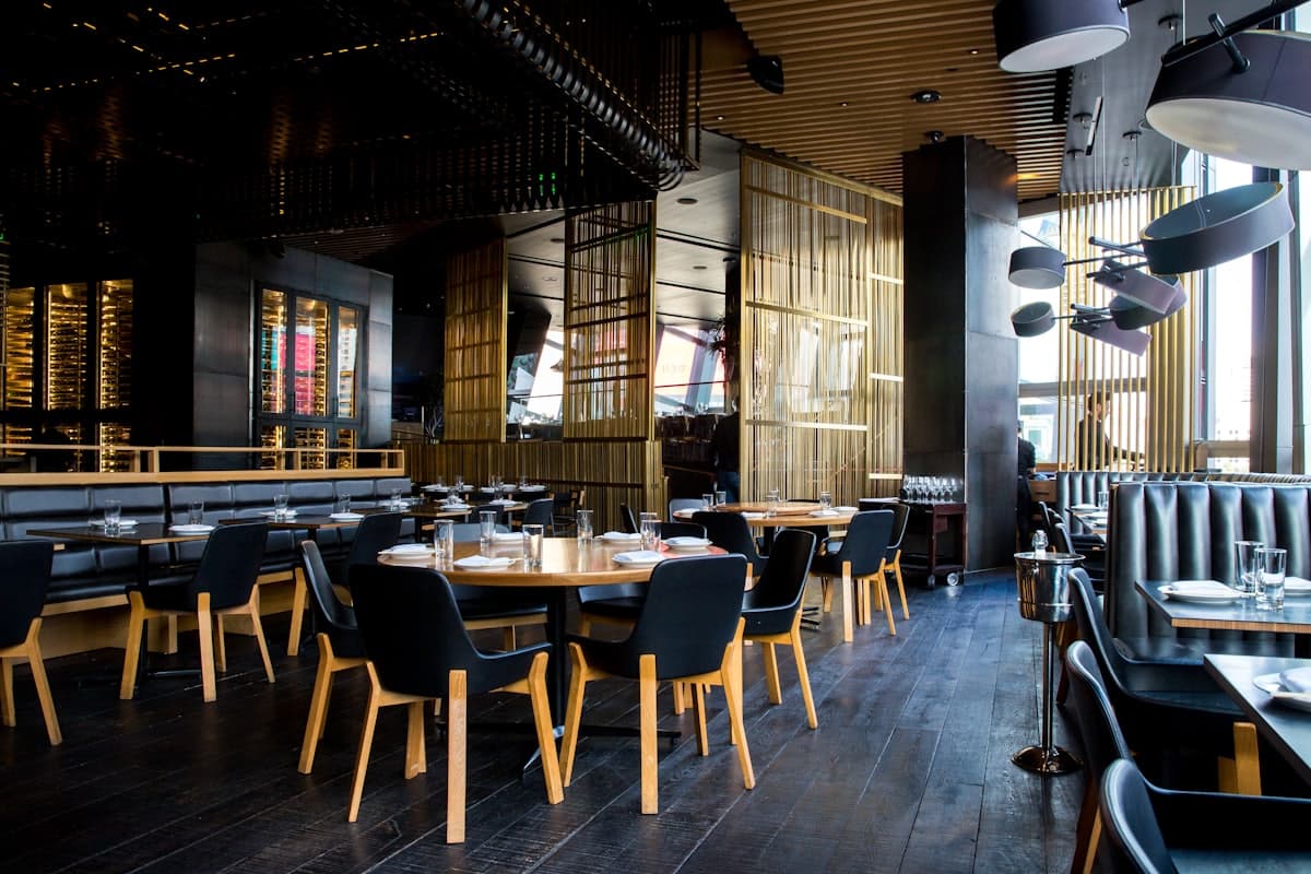 Sala de restaurante com mesas postas e luz quente